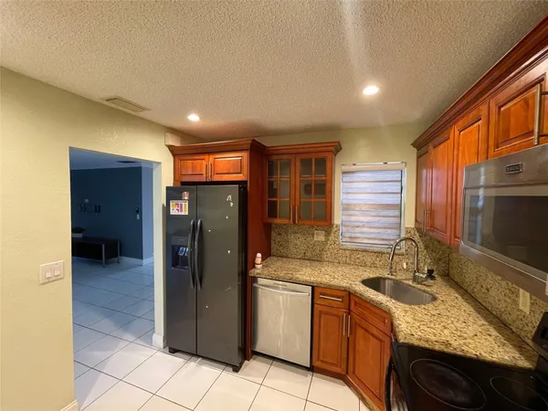 a kitchen with stainless steel appliances granite countertop a sink stove and refrigerator