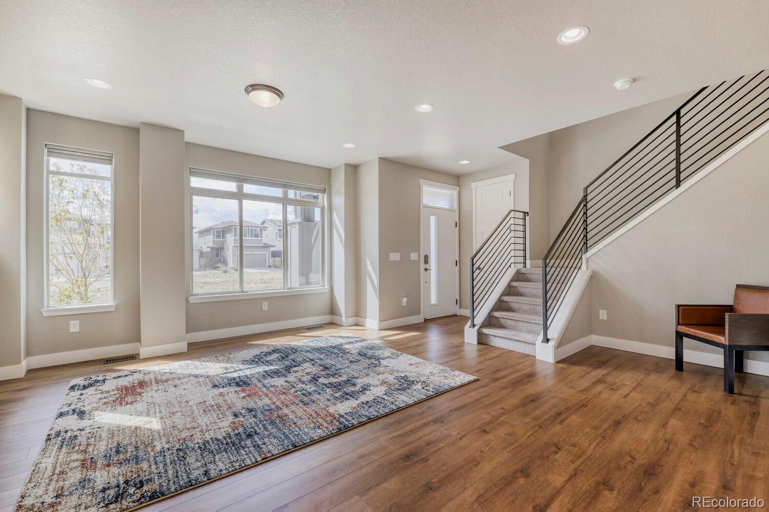 6850 Decatur Street Denver, CO 80221 - Photo 13 of 30 a view of an empty room with stairs wooden floor and a window