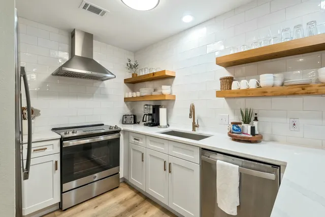 a kitchen with stainless steel appliances a stove a sink and a microwave