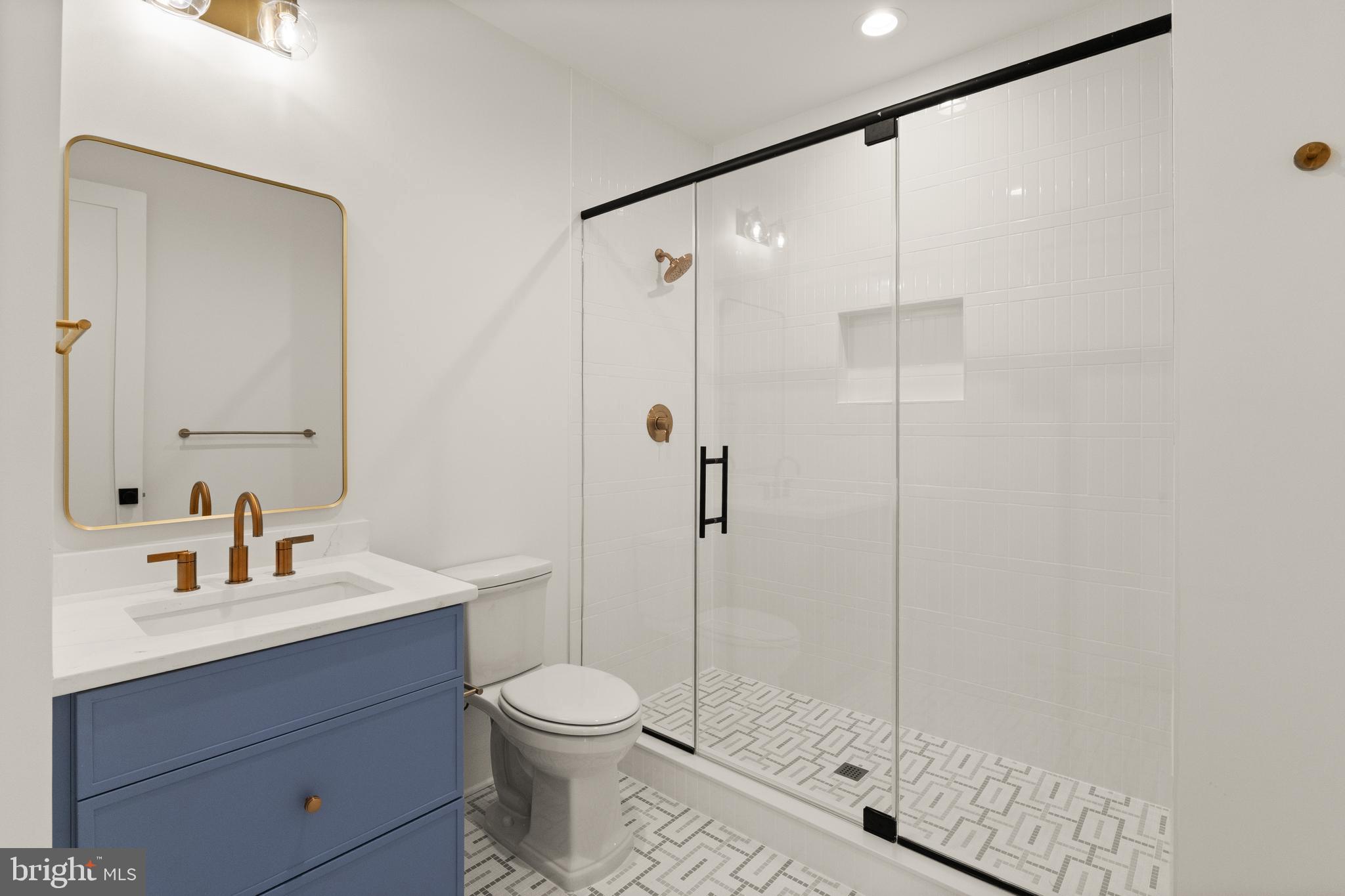 5804 Ridgefield Road Bethesda, MD 20816 - Photo 40 of 53 a bathroom with a shower sink vanity mirror and toilet
