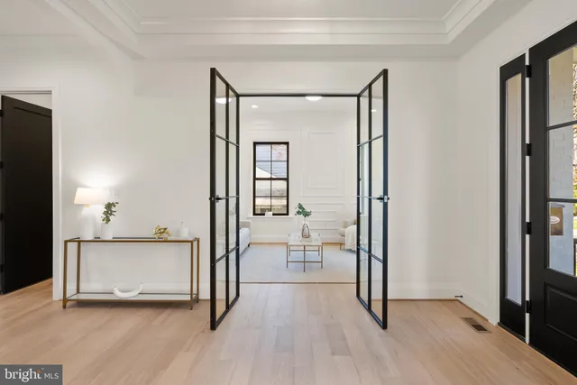 a view of a hallway with wooden floor and livingroom with furniture