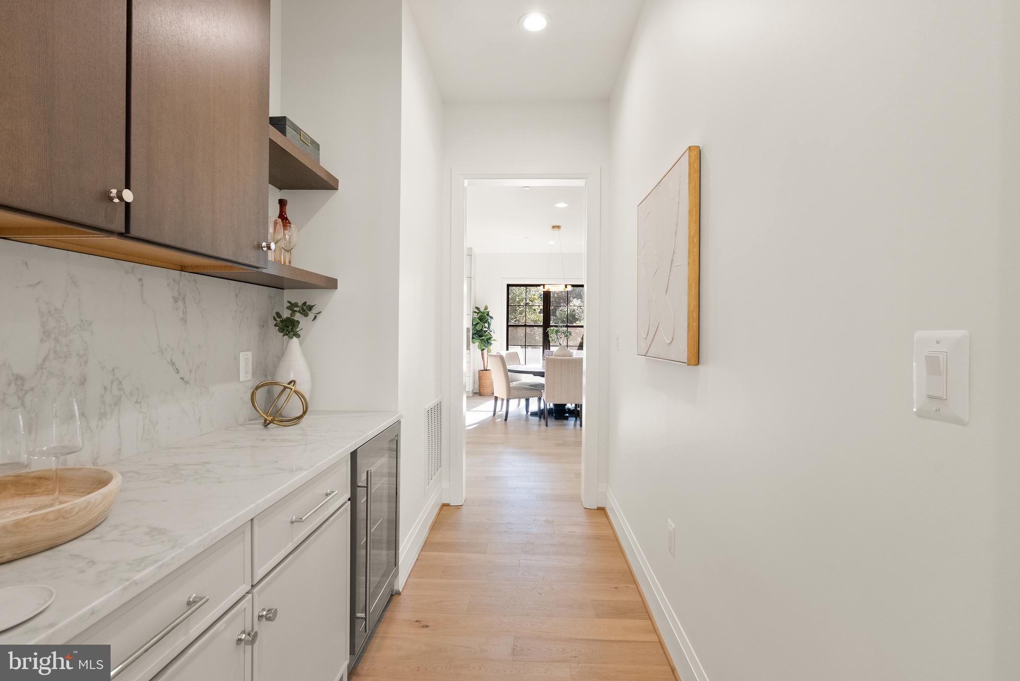 5804 Ridgefield Road Bethesda, MD 20816 - Photo 9 of 53 a hallway with white cabinets and wooden floor