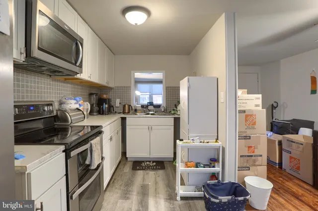 a kitchen with a refrigerator and white cabinets