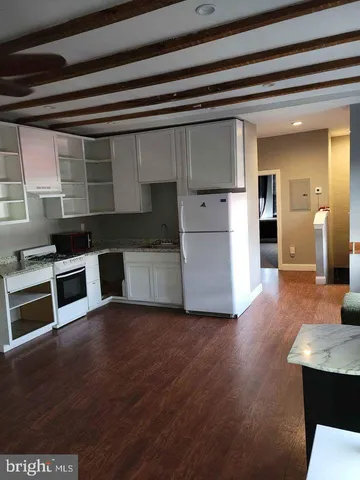 a view of a kitchen with furniture and wooden floor