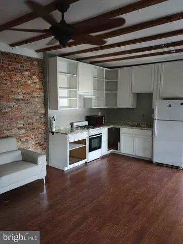 a kitchen with stainless steel appliances wooden cabinets and a wooden floor
