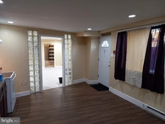 an empty room with wooden floor and entrance