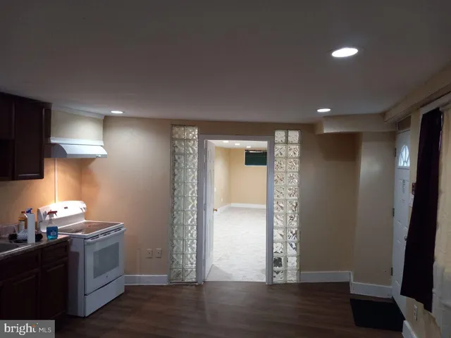 a view of an empty room with wooden floor and a cabinet