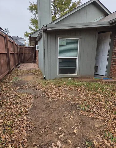 a view of backyard with wooden fence