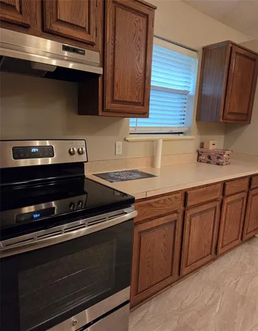 a kitchen with granite countertop a stove microwave and sink