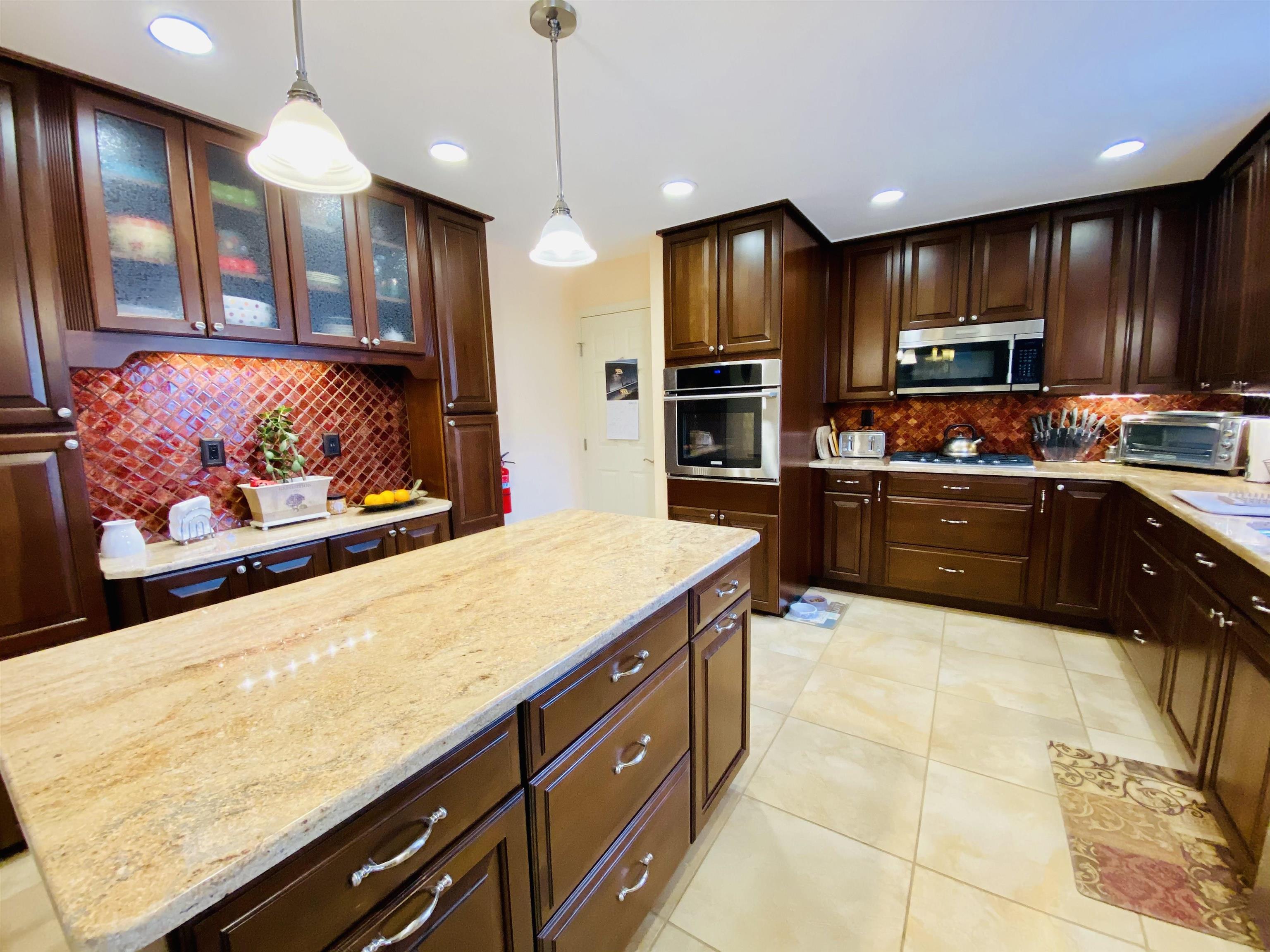 204 Bliss Avenue Somers Point, NJ 08244 - Photo 4 of 18 a kitchen with stainless steel appliances wooden cabinets a stove top oven a sink and dishwasher