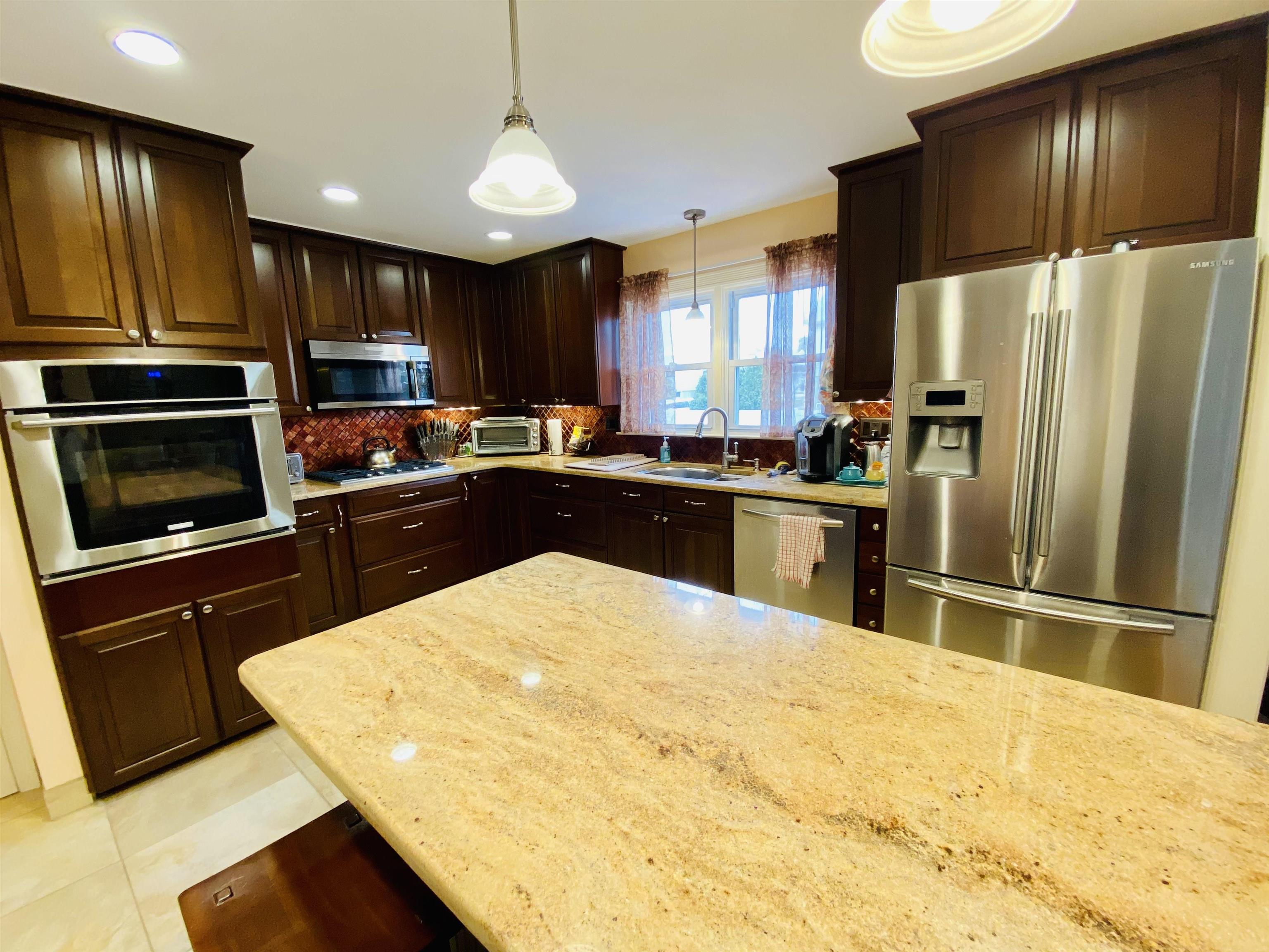 204 Bliss Avenue Somers Point, NJ 08244 - Photo 5 of 18 a kitchen with stainless steel appliances kitchen island granite countertop a refrigerator stove top oven and sink
