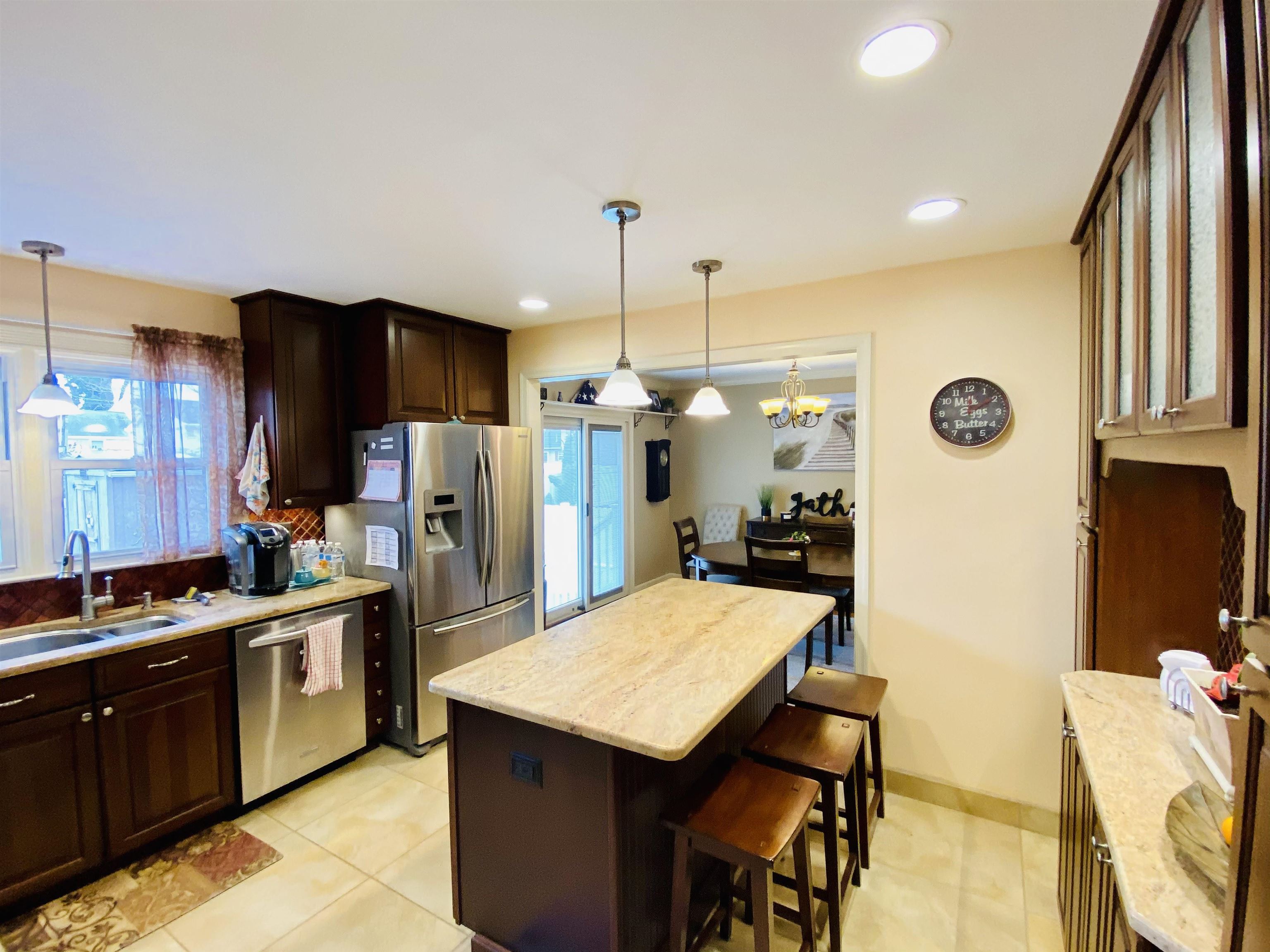 204 Bliss Avenue Somers Point, NJ 08244 - Photo 6 of 18 a kitchen with stainless steel appliances kitchen island granite countertop a refrigerator a stove a sink dishwasher with a dining table and chairs
