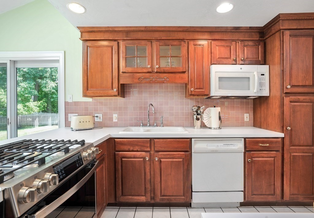 40 Upland Road Duxbury, MA 02332 - Photo 18 of 38 a kitchen with stainless steel appliances granite countertop a stove a sink dishwasher and cabinets with wooden floor