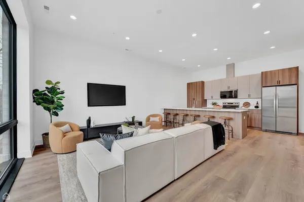 a living room with furniture kitchen and a flat screen tv