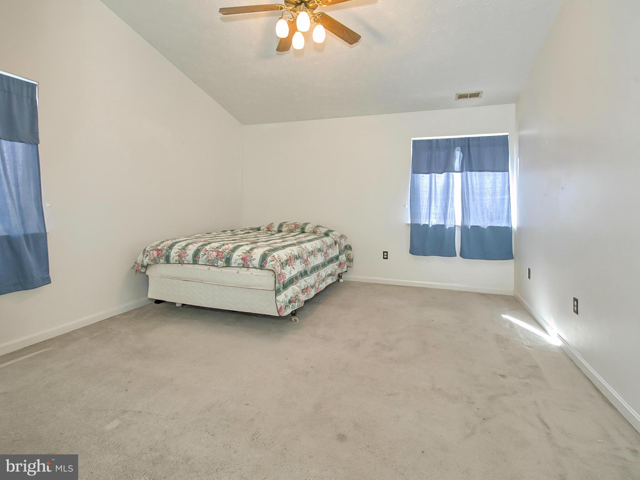 2137 Wainwright Court, Unit 2B Frederick, MD 21702 - Photo 17 of 30 a spacious bedroom with a bed and a chandelier