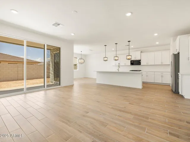 a view of kitchen with stainless steel appliances refrigerator oven and white cabinets