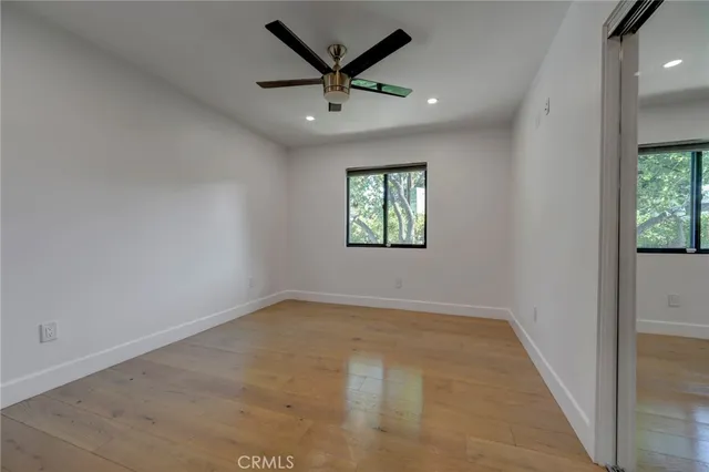 an empty room with windows and fan