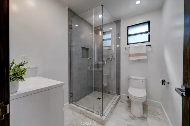 a bathroom with a shower sink mirror and toilet