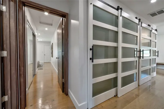 a view of a hallway with wooden floor and closet