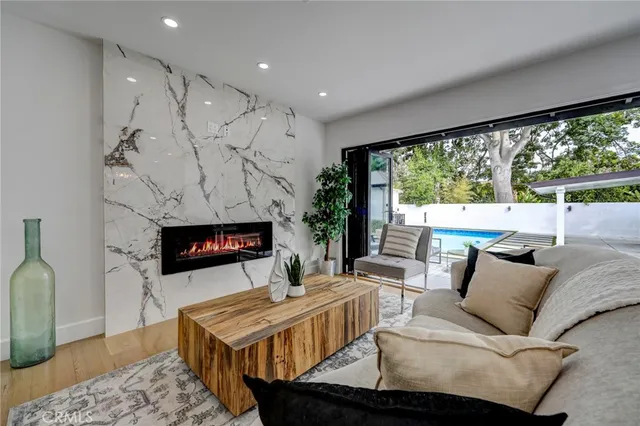 a living room with furniture a large window and a fireplace