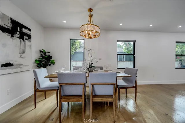 a view of a dining room with furniture wooden floor and a chandelier
