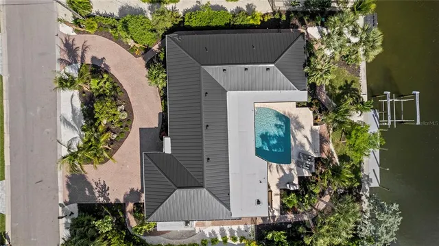 a front view of a house with a yard and potted plants