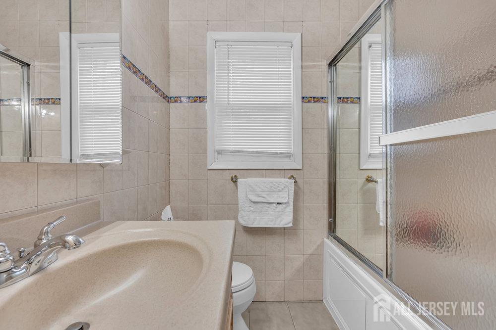 10 Kings Road East Brunswick, NJ 08816 - Photo 18 of 33 a bathroom with a tub sink and mirror
