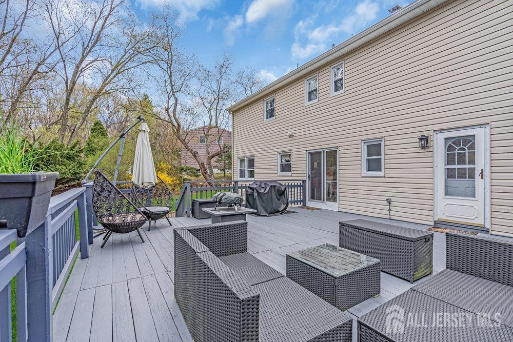 10 Kings Road East Brunswick, NJ 08816 - Photo 27 of 33 a view of a patio with couches and dining table and chairs with wooden floor
