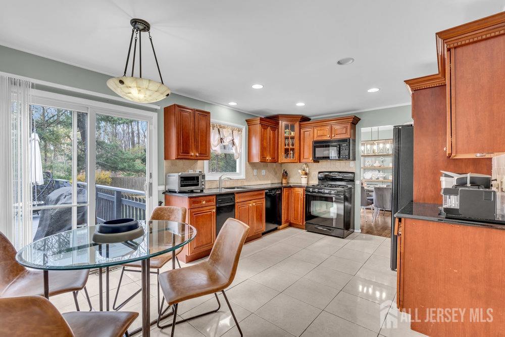 10 Kings Road East Brunswick, NJ 08816 - Photo 5 of 33 a kitchen with stainless steel appliances granite countertop a refrigerator a stove top oven a sink dishwasher a dining table and chairs with wooden floor