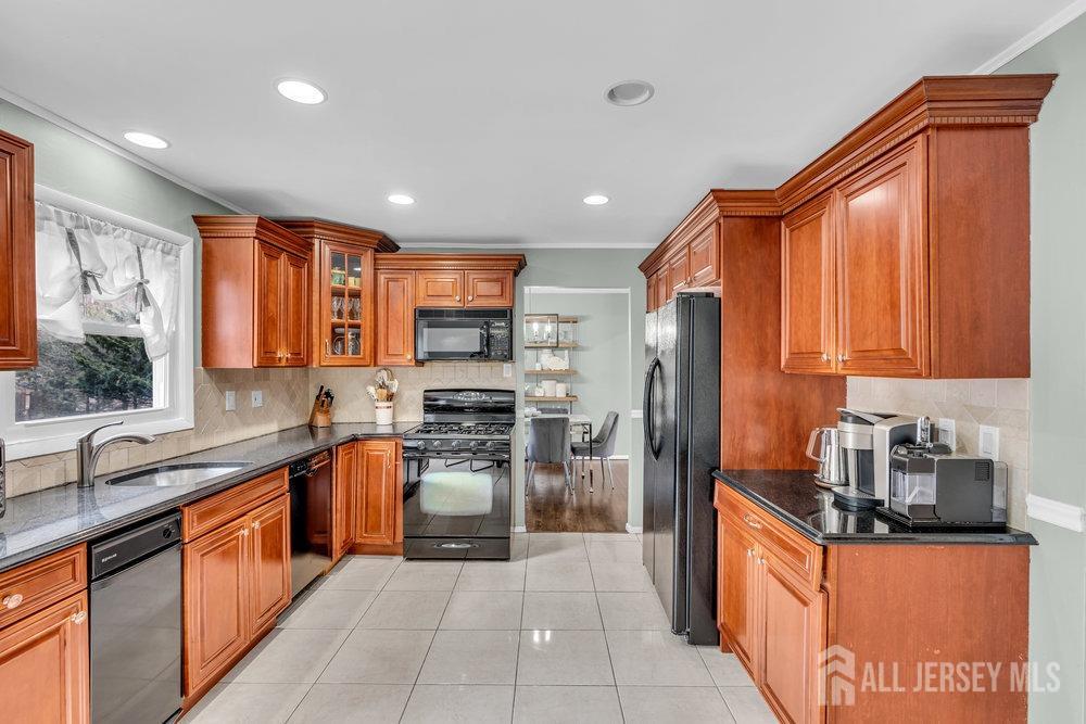 10 Kings Road East Brunswick, NJ 08816 - Photo 9 of 33 a kitchen with stainless steel appliances granite countertop wooden cabinets a sink dishwasher a stove and a refrigerator