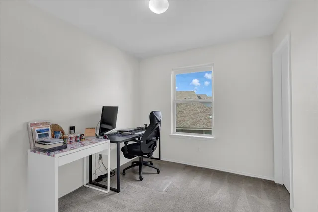 a view of a workspace with furniture and a window