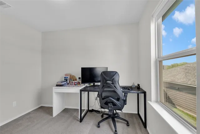 a view of a workspace with furniture and a window