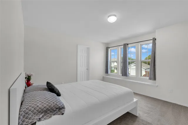 a bed sitting in a bedroom next to a window