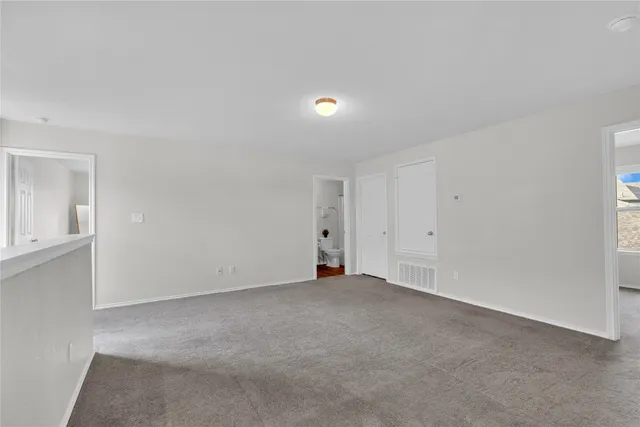 a view of an empty room with wooden floor and entryway
