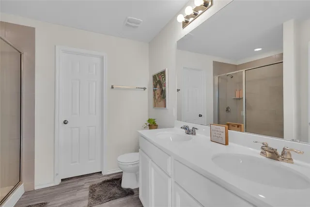 a bathroom with a sink a toilet and shower