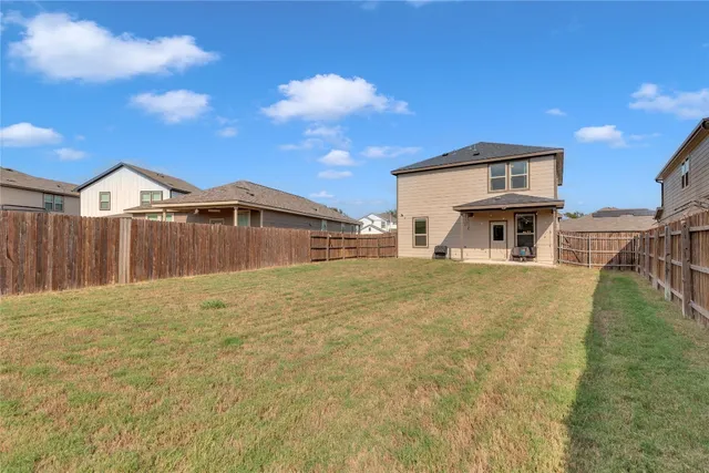 a front view of a house with large trees