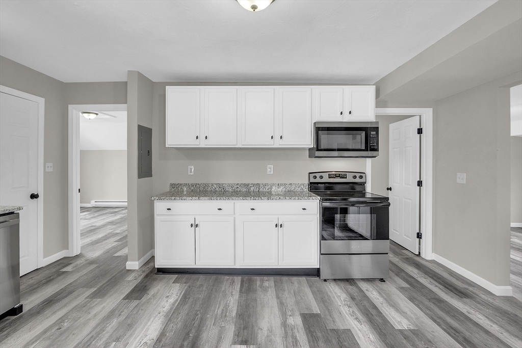 73 Ash Street Gardner, MA 01440 - Photo 2 of 40 a kitchen with granite countertop white cabinets and stainless steel appliances