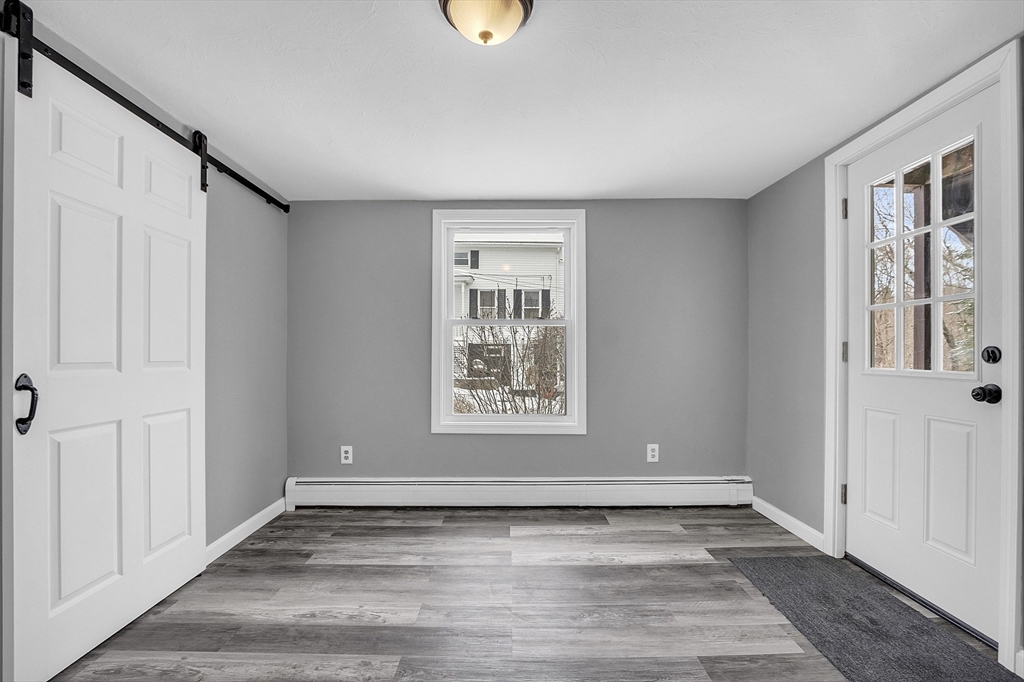 73 Ash Street Gardner, MA 01440 - Photo 28 of 40 a view of an empty room with window and wooden floor