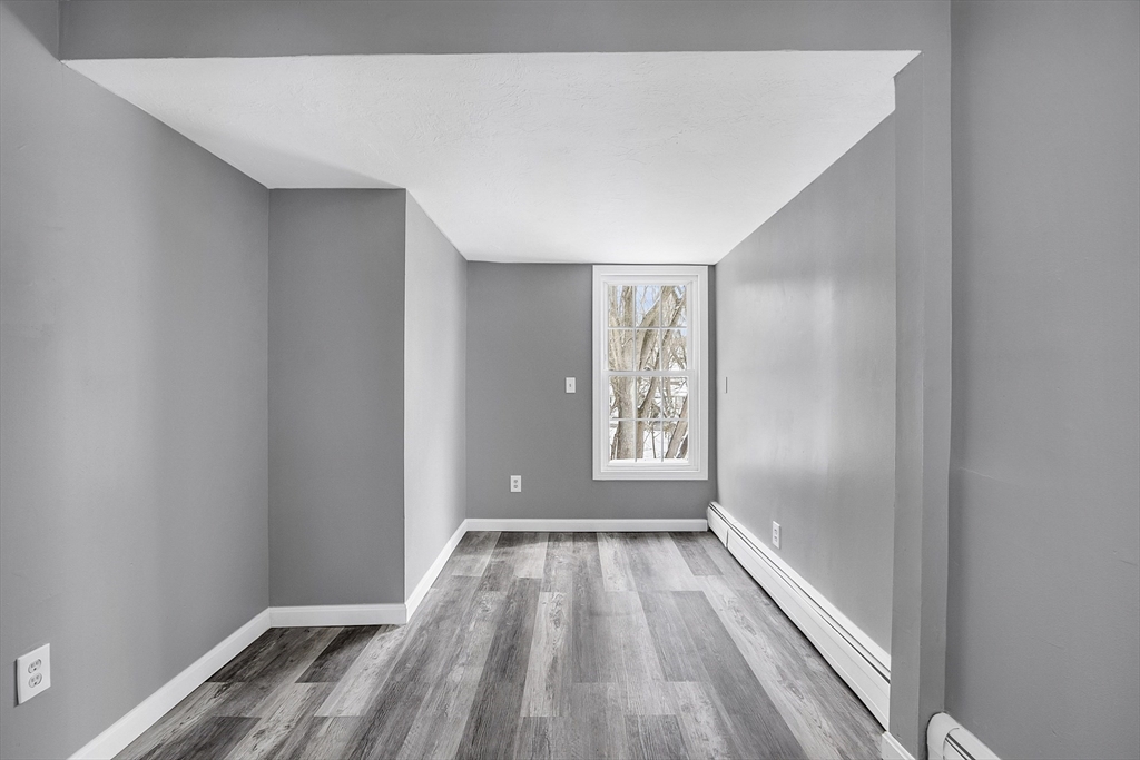 73 Ash Street Gardner, MA 01440 - Photo 29 of 40 a view of an empty room with wooden floor and a window