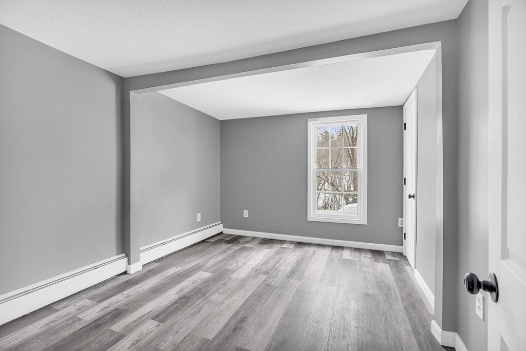 73 Ash Street Gardner, MA 01440 - Photo 31 of 40 a view of an empty room with wooden floor and a window