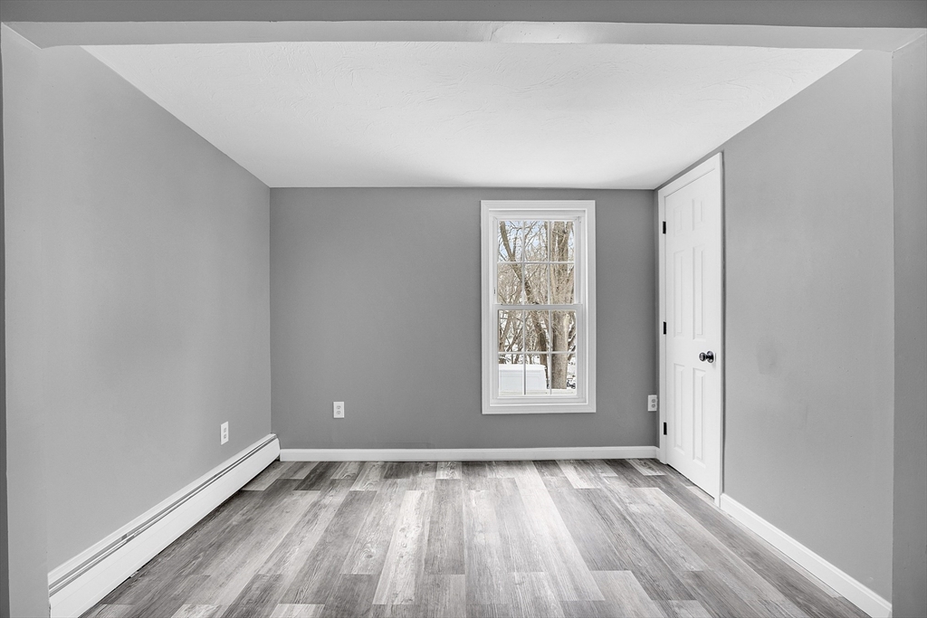 73 Ash Street Gardner, MA 01440 - Photo 32 of 40 an empty room with wooden floor and windows