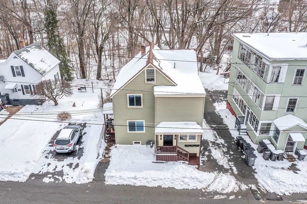 73 Ash Street Gardner, MA 01440 - Photo 35 of 40 a view of a white house with large windows and wooden fence