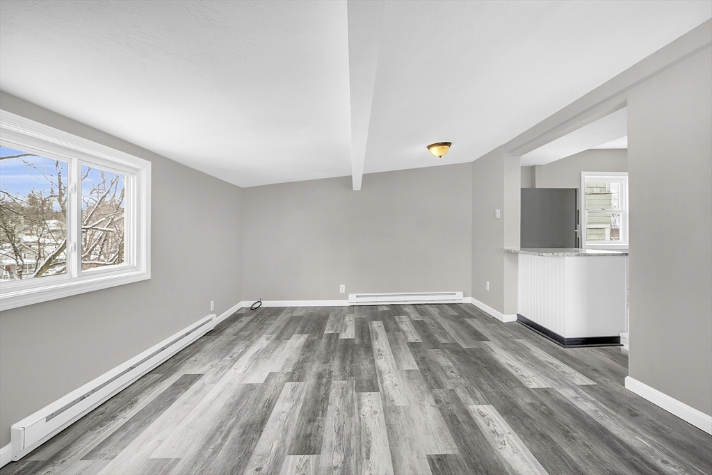 73 Ash Street Gardner, MA 01440 - Photo 7 of 40 a view of an empty room with wooden floor and a window