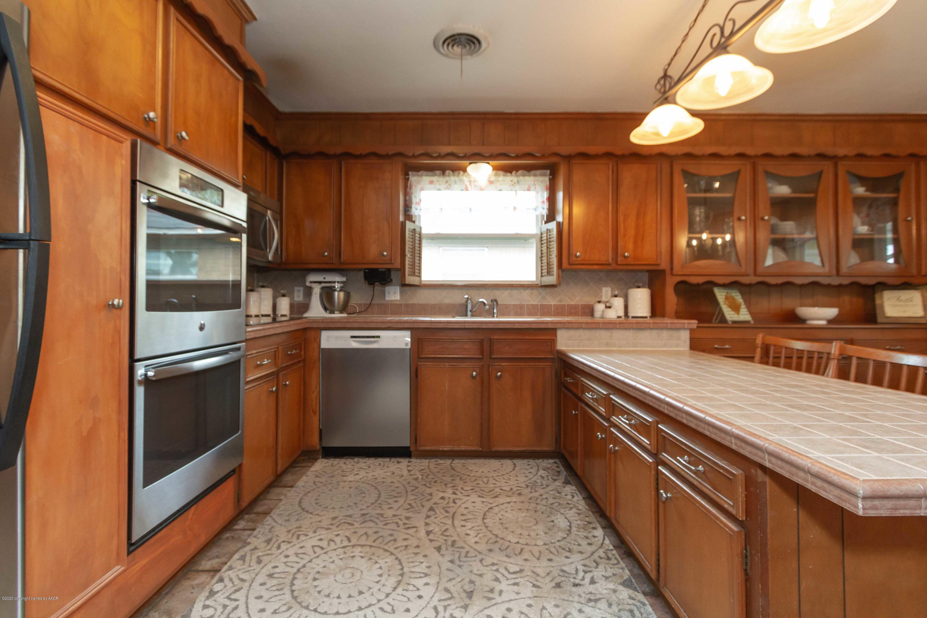 7206 Calumet Road Amarillo, TX 79106 - Photo 22 of 44 a kitchen with stainless steel appliances granite countertop a sink a stove and a refrigerator