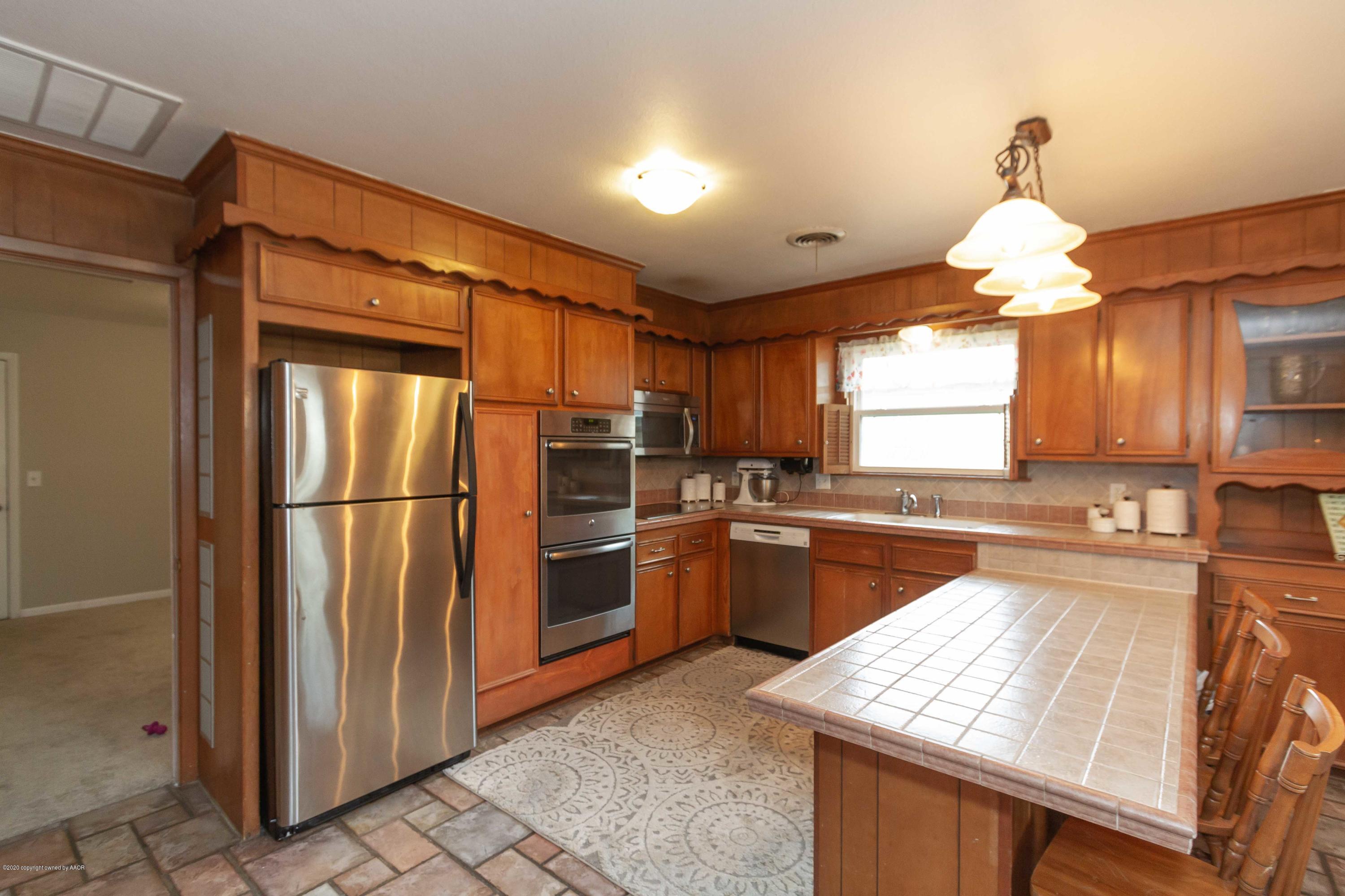 7206 Calumet Road Amarillo, TX 79106 - Photo 5 of 44 a kitchen with granite countertop a refrigerator and a sink