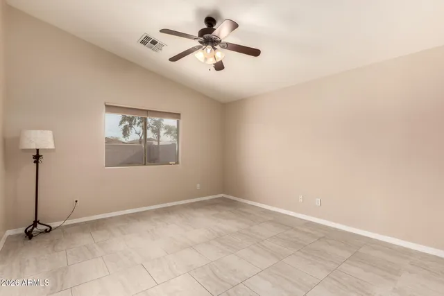 an empty room with windows and ceiling fan