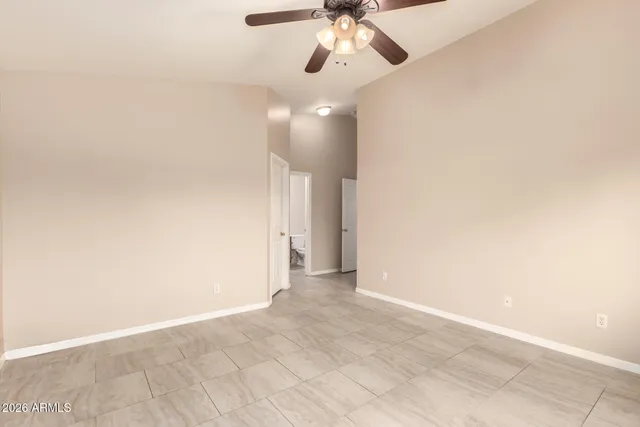 a view of an empty room and chandelier fan