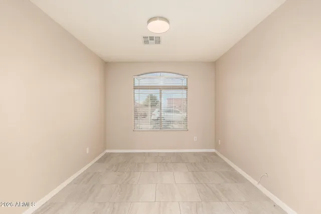 an empty room with a window and a chandelier