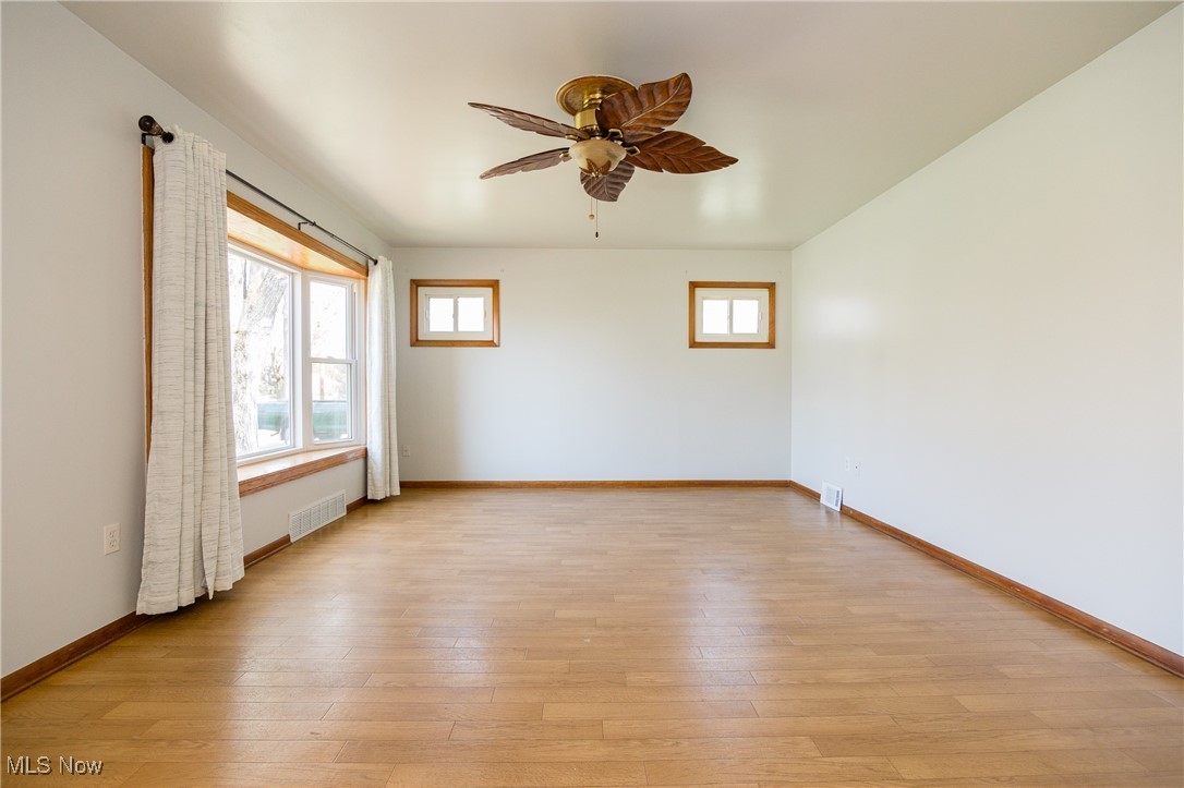 32575 Bagley Road North Ridgeville, OH 44039 - Photo 12 of 30 Unfurnished room with visible vents, a ceiling fan, light wood finished floors, and baseboards