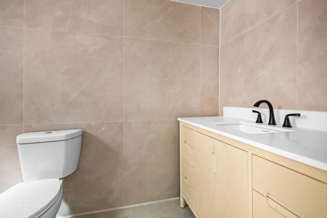 a bathroom with a toilet a sink and mirror